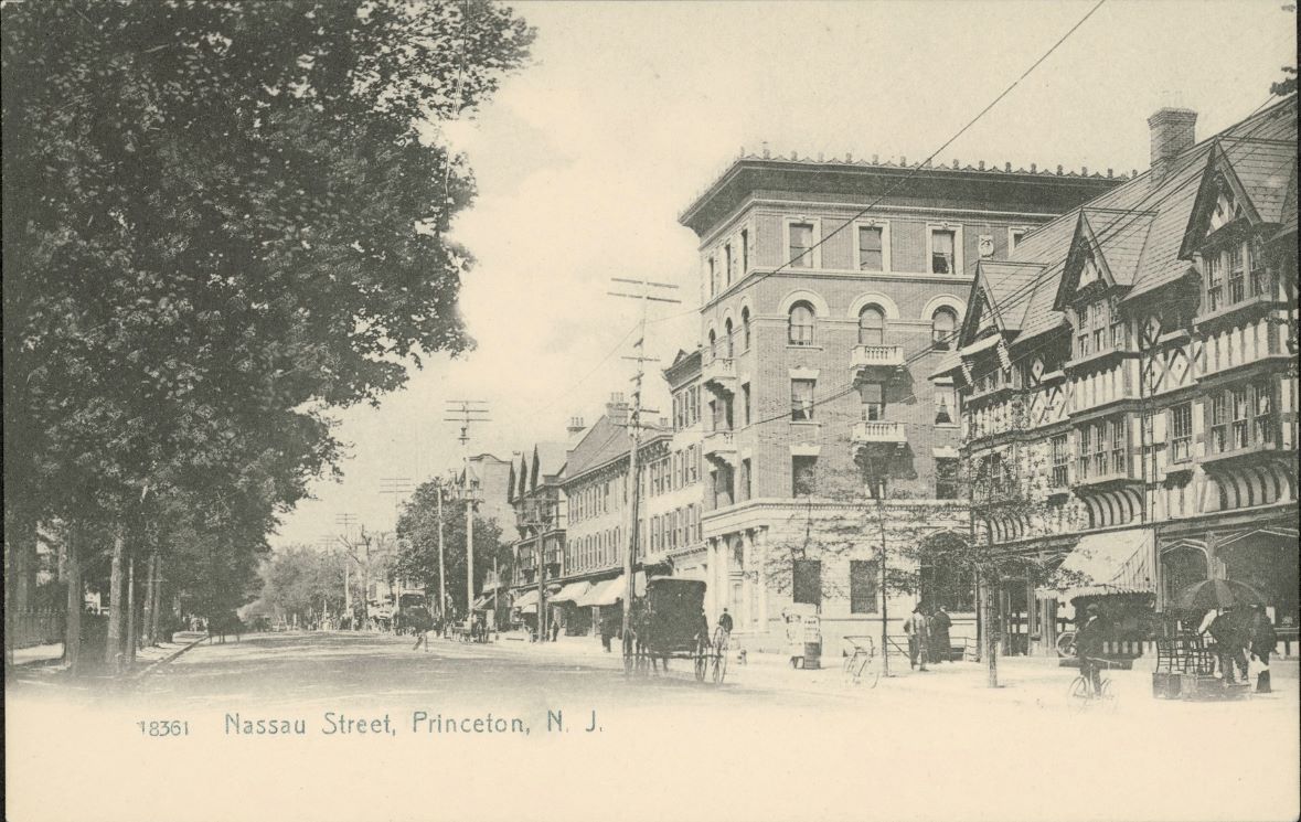 A road with trees on the left and buildings on the other has a few people and carriages.